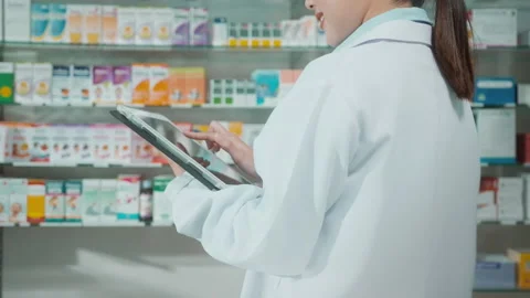 Portrait of female pharmacist using tablet in a modern pharmacy drugstore. Видео 204827081