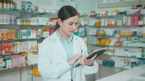 Portrait of female pharmacist using tablet in a modern pharmacy drugstore. 動画素材 204827126