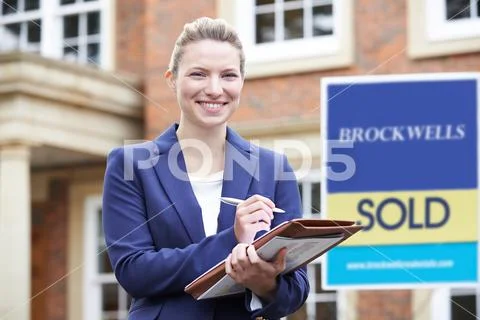 Portrait Of Female Realtor Standing Outside Residential Property Stock Photos