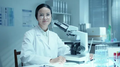 Portrait of Female Scientist Working with Microscope at Desk in Laboratory Stock Footage 275481227