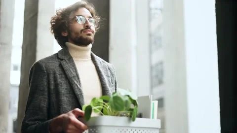 Portrait of fired sad young arabian businessman carries his box with personal Stock Footage 237017481