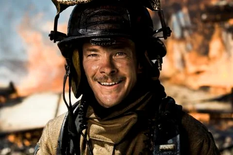 Portrait of a firefighter with fire in background Stock Photos
