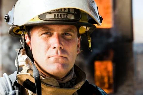 Portrait of a firefighter with fire in background Stock Photos