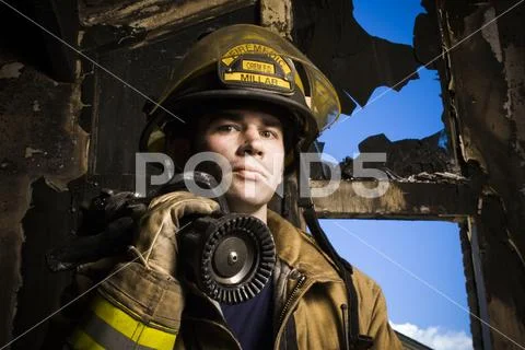 Portrait of a firefighter with fire hose Stock Photos