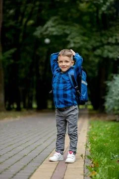 Portrait of a first grader with a backpack. The boy goes to school Stock Photos