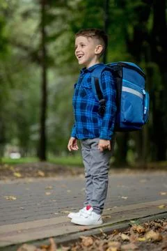 Portrait of a first grader with a backpack. The boy goes to school Stock Photos