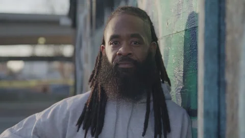 Portrait of Fit Man with Dreadlocks and Beard Outside at Sunset Stock Footage 270397326
