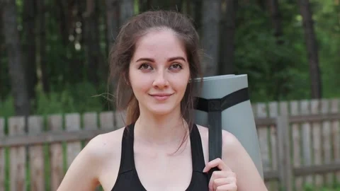 Portrait of fitnesswoman in black outfit look at camera in the forest Stock Footage