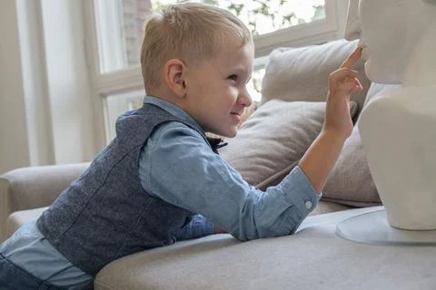 Portrait of a five-year-old boy in profile. Boy touches a plaster bust while  Stock Photos