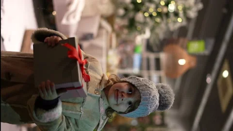 Portrait fo a dorable little girl holds gift box with Christmas supply store Stock Footage 166323982