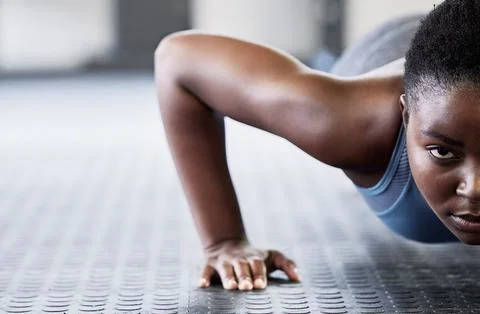 Portrait, focus and push ups with a black woman on the floor of a gym for Stock Photos