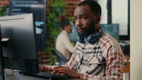 Portrait of focused african american programer wearing wireless headphones Stock Footage 168240022