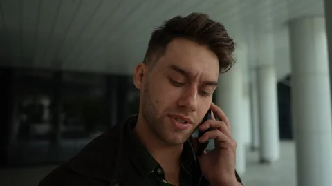 Portrait of focused young man having unpleasant conversation on mobile phone Stock Footage 296582584