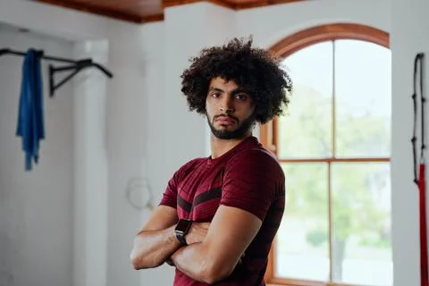 Portrait of focused young middle eastern man with arms crossed at the gym Stock Photos
