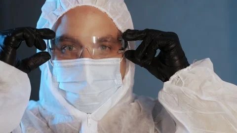 Portrait of a forensic expert in a protective suit, mask and glasses. Stock Footage 316734965