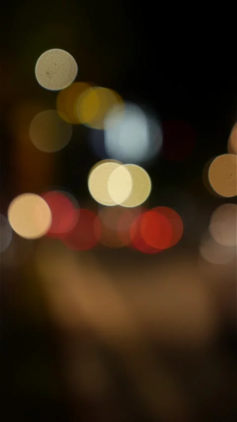 Portrait format view of blurred vehicle lights and street illumination forming Stock Footage 331011691