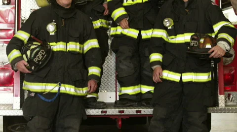 Portrait of four firefighters posing by fire engine in garage Stock Footage 866736