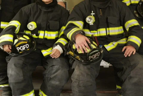 Portrait of four firefighters posing by fire engine in garage Stock Footage 866759