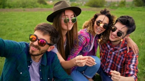 Portrait of four happy hipsters while they making selfie with sparklers  Stock Footage 75765193