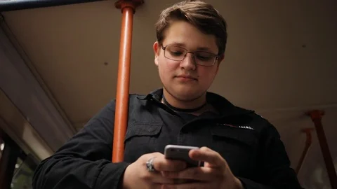 Portrait frame from below young man with glasses chatting on smartphone standing Stock Footage 98148859