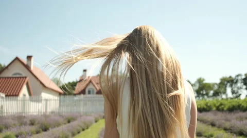 Portrait frame of a blonde walking in a white dress on a lavender field Stock Footage 141044889