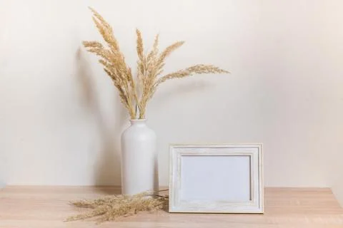 Portrait frame mock up with dried flowers on wooden table Stock Photos