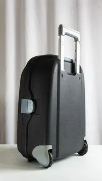 Portrait frame of standing suitcase viewed from the side, white textured ba.. Stock Photos
