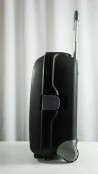 Portrait frame of standing suitcase viewed from the side, white textured ba.. Stock Photos