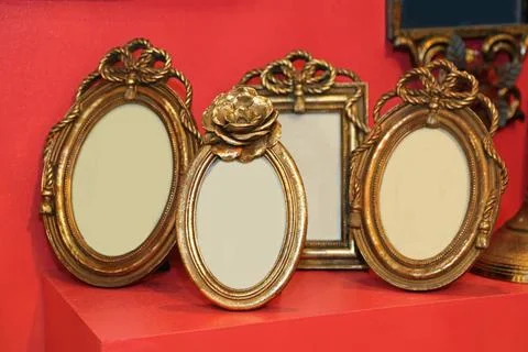 Portrait Frames Small Oval Gold Portrait Frames at Red Table Copyright: xZ... Stock Photos