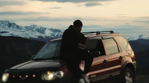 Portrait of freelancer working on a laptop while sitting on a car. Stock Footage 312191432