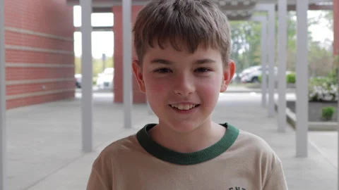 Portrait Friendly Boy Standing Outside Elementary School Building. School B.. Vídeos de archivo 332814810