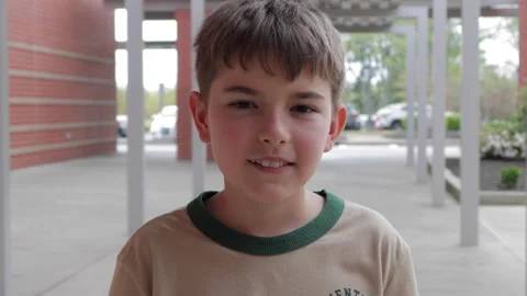 Portrait Friendly Boy Standing Outside Elementary School Building. School B.. Video stock 342622559
