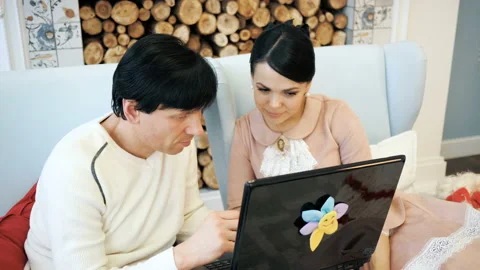 Portrait of a friendly couple having fun on laptop at home indoor Stock Footage 104284308