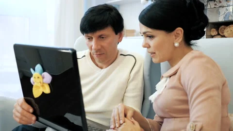 Portrait of a friendly couple having fun on laptop at home indoor Stock Footage 104285757