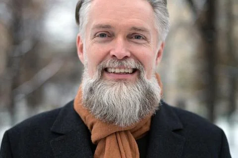 Portrait of friendly gray-haired man who looks at the camera and smiles Stock Photos