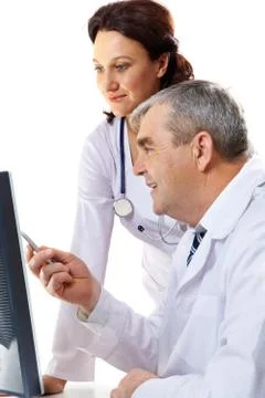 Portrait of friendly therapists looking at computer monitor where senior man poi Stock Photos