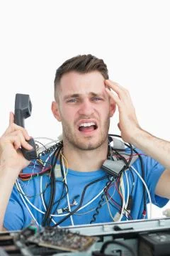 Portrait of frustrated computer engineer on call in front of open cpu Foto stock