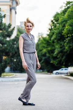 Portrait full length of pretty looking woman walking outdoors on city street and Stock Photos