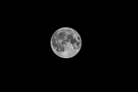 A portrait of a full moon shining bright at night in the darkness of endless  Stock Photos