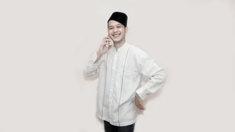 Portrait of Funny an asian muslim man with head cap taking a call Stock Photos
