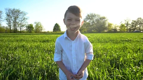 Portrait of a funny boy in a field at sunset Stock Footage 89235582
