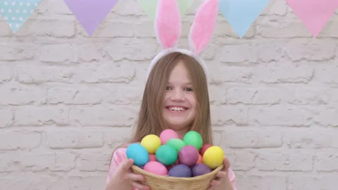 Portrait of funny Easter kid wearing bunny ears with colorful eggs Video stock 171221780