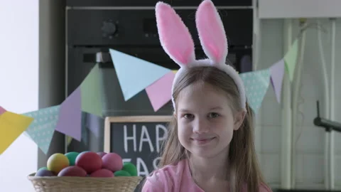Portrait of funny Easter kid wearing bunny ears in decorated kitchen Stock Footage 171611668