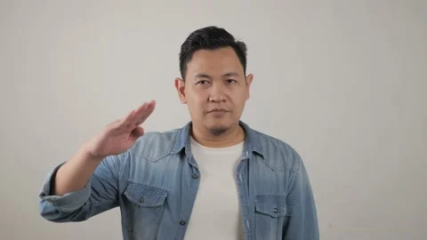 Portrait of funny young Asian man looking at camera, saluting gesture Video stock 143760053