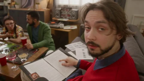 Portrait of Game Master Reading Script for RPG Tabletop Game with Friends Stock Footage 335864640