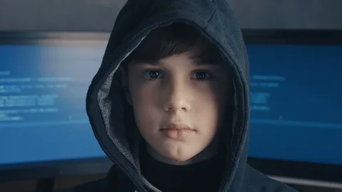 Portrait of a genius boy hacker prodigy in the hood on the background of Vidéo 101995457