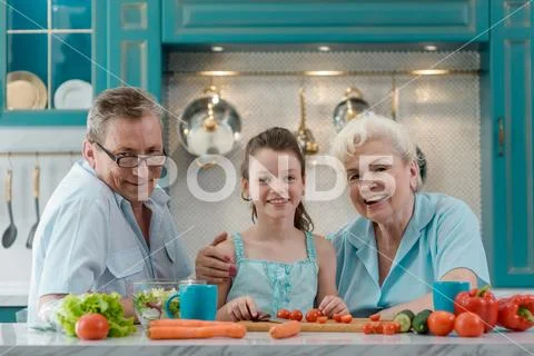 Portrait of girl and grandparents at the table in kitchen Stock Photos