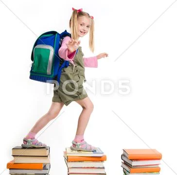 Portrait of girl with backpack walking from top to top of book piles Stock Photos