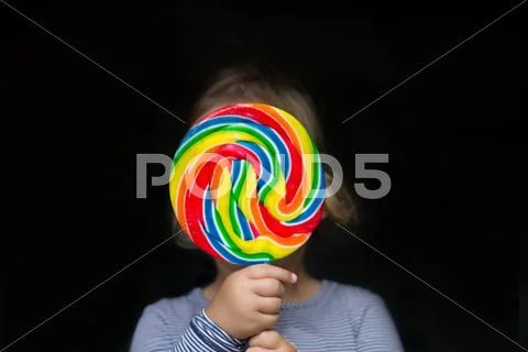 Portrait of a girl holding a multi-colored lollipop Stock Photos