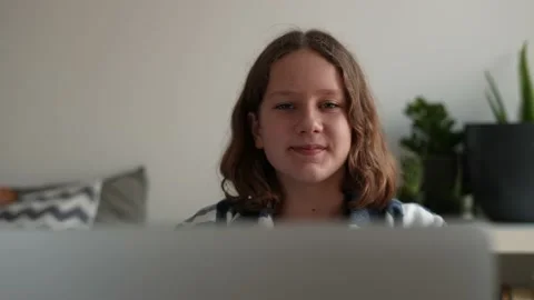Portrait of a girl looking at the camera with a comp studying online from home Stock Footage 166325387